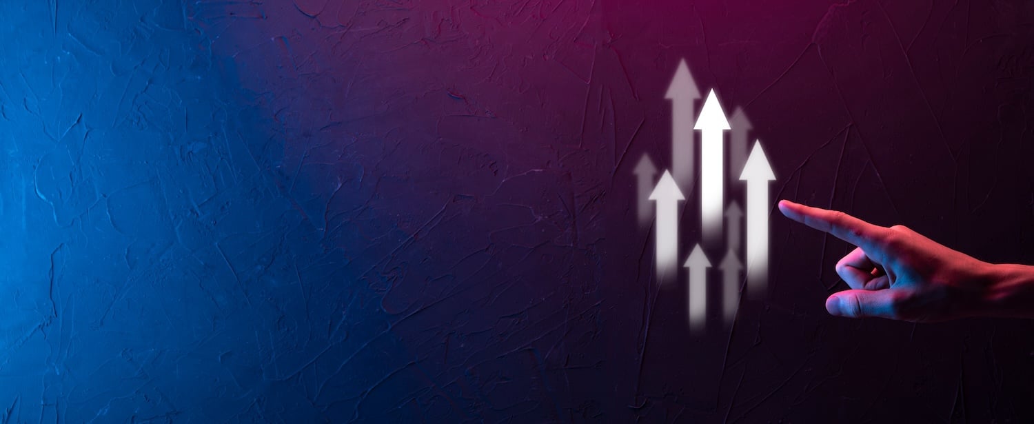 Stuck with a site that doesn’t perform? A hand pointing towards upward-facing arrows on a textured, gradient background transitioning from blue to pink. The arrows symbolize progress or growth.